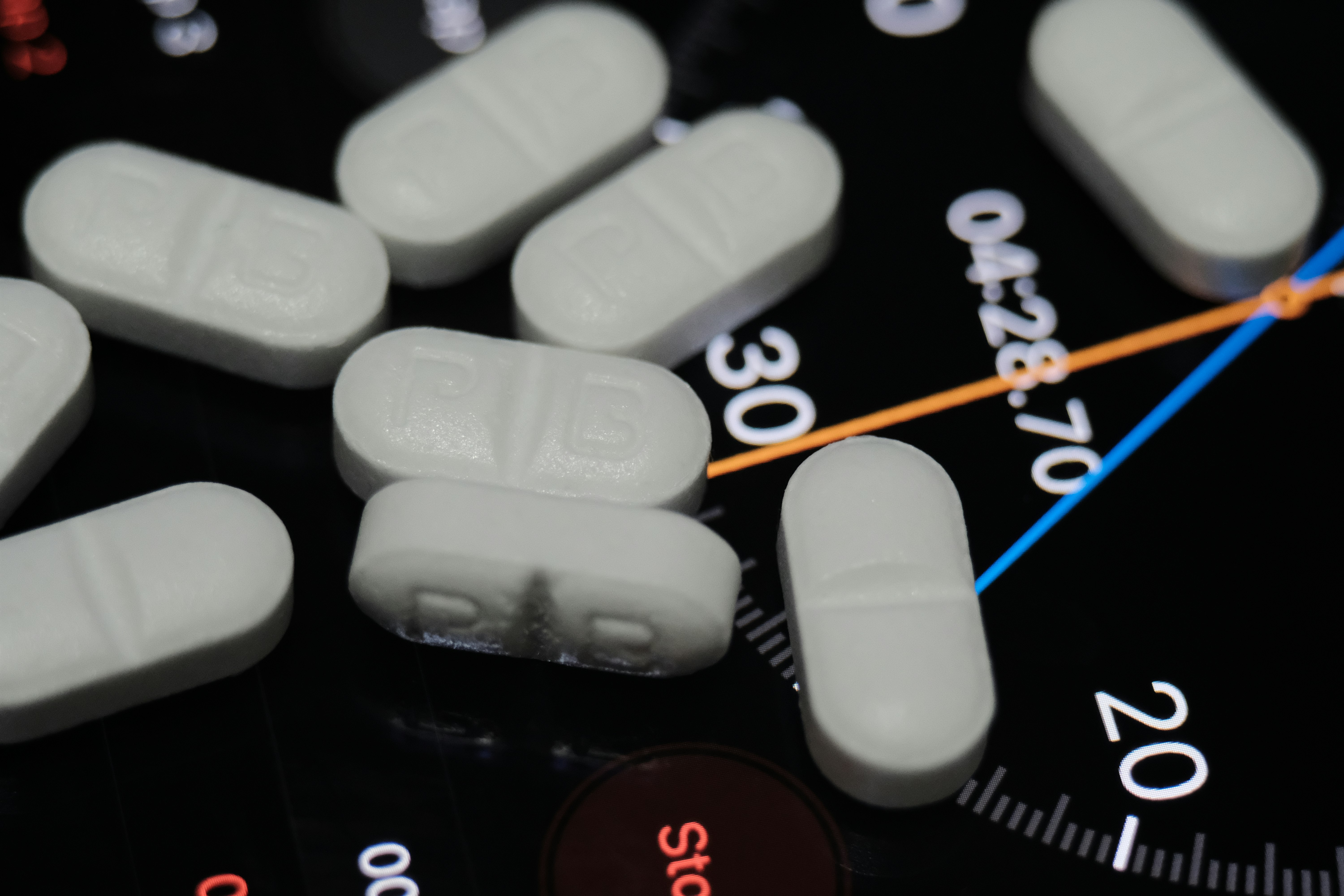 white medication pill on black and white remote control
